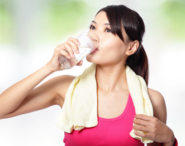 Young Woman Drinking Water After Workout